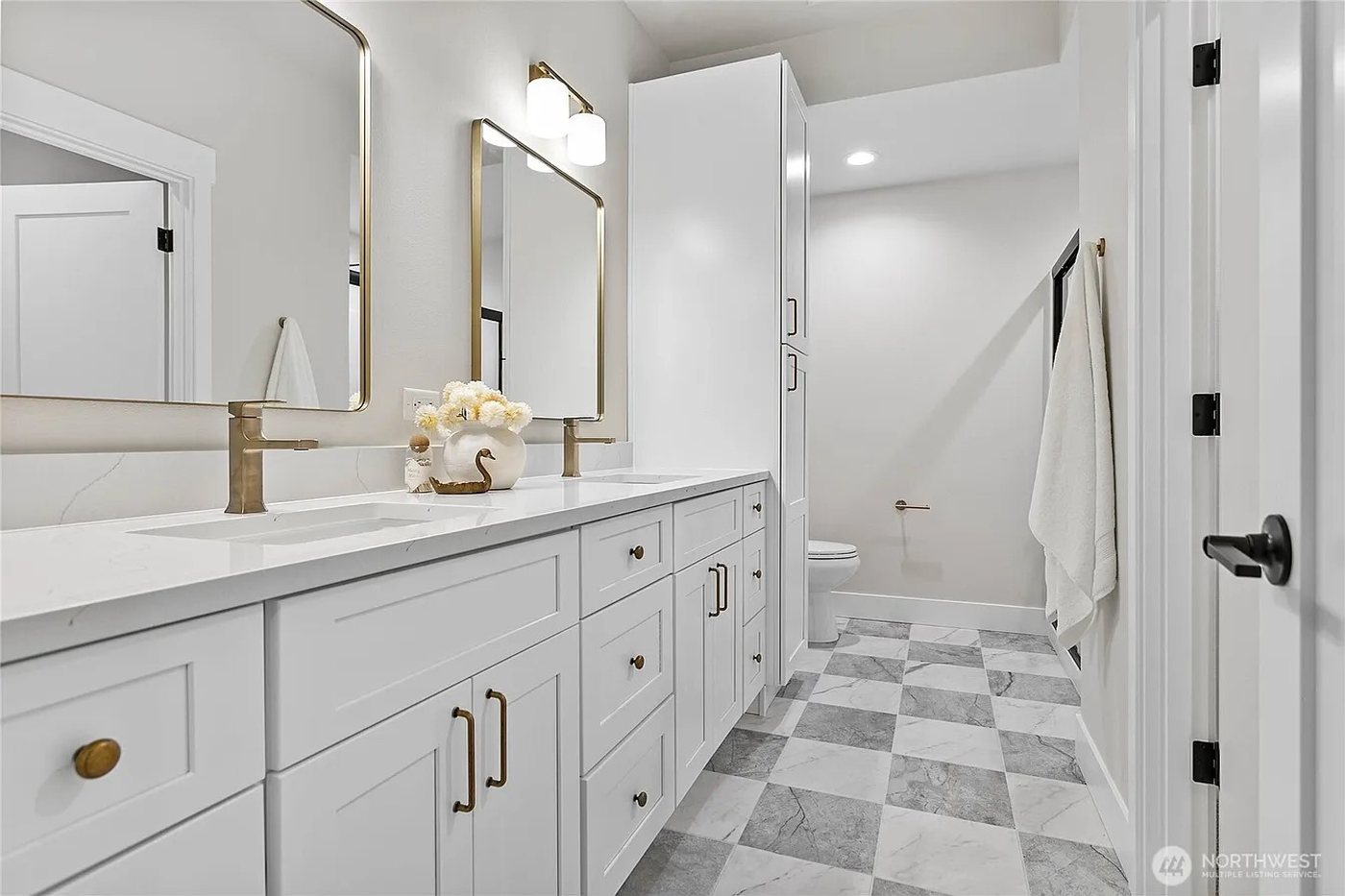Double vanity with quartz counters and marble checkerboard floor
