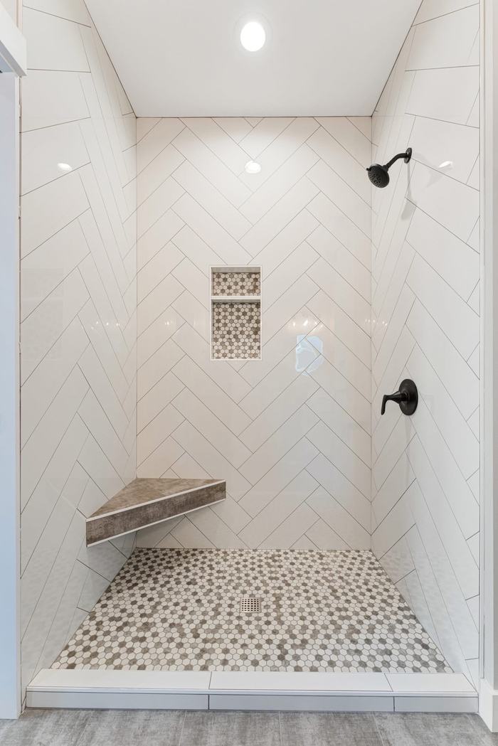 Herringbone tile shower with pebble floor